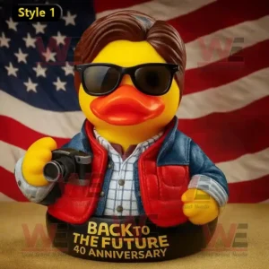 A yellow duck wearing sunglasses and a red vest holding a camera with an American flag in the background.