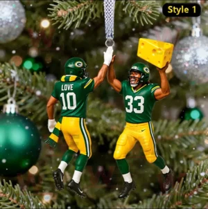 Two Green Bay Packers football players in green and yellow uniforms high fiving as Christmas ornaments on a tree.