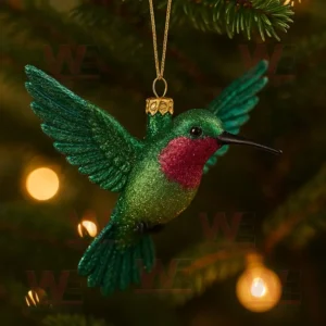 Sparkling green and red hummingbird ornament hanging on a Christmas tree branch.