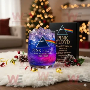 Pink Floyd 60th Anniversary Whiskey Glass 4 A Pink Floyd 60th Anniversary glass with purple ice beside a black box and Christmas decorations!