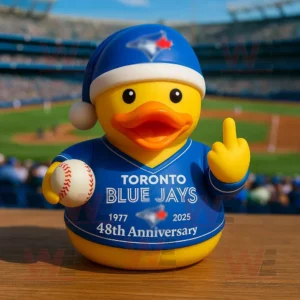 A rubber duck wearing a Toronto Blue Jays outfit holding a baseball on a stadium background.