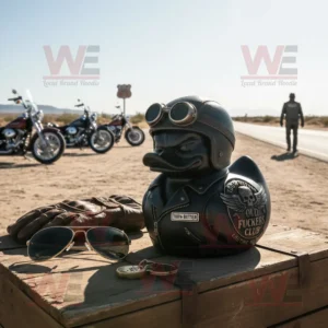Biker themed rubber duck on table beside gloves and sunglasses with motorcycles in desert background!
