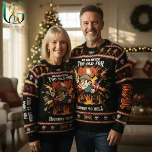 Couple in matching AC DC Highway To Hell sweaters posing in a festive living room with Christmas tree and lights!