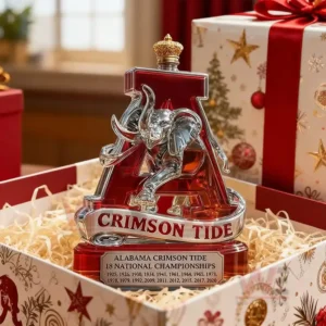 The image features an ornate Alabama Crimson Tide trophy bottle situated in a team exhibition space surrounded by jerseys photos and memorabilia!