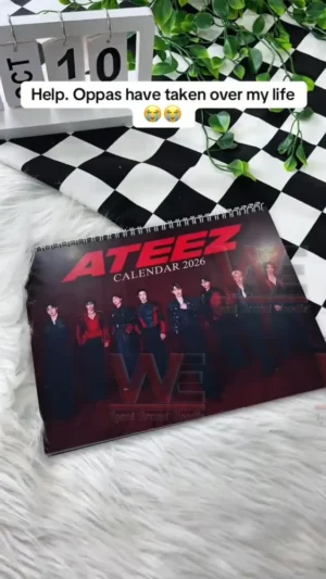 ATEEZ 2026 calendar cover on a soft furry surface with aesthetic decorations in the background!