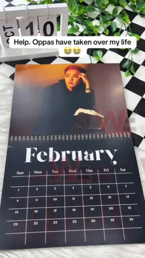 ATEEZ 2026 calendar February page showing a member with red hair and a relaxed pose against a warm background!