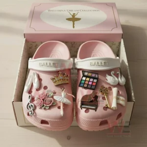 Pink ballet themed clogs displayed in an open box with multiple decorative charms attached to the front of each shoe!