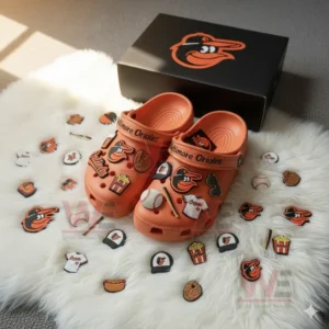 Orange Baltimore Orioles clogs with assorted charms displayed on a white furry background!
