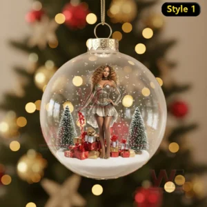 Beyonce Queen B Christmas Ornament 10 A clear Christmas ornament showing a woman standing in a snowy scene with trees and gifts!