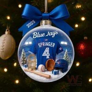 A Blue Jays 2025 Christmas ornament with a Springer number 4 jersey and baseball gear inside a clear glass ball decorated with a blue ribbon!