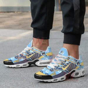 A close-up of a person wearing Bluey-themed sneakers with paw prints and Bluey character graphics.
