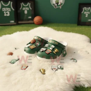Green Boston Celtics clogs with multiple basketball charms displayed on a white furry surface!