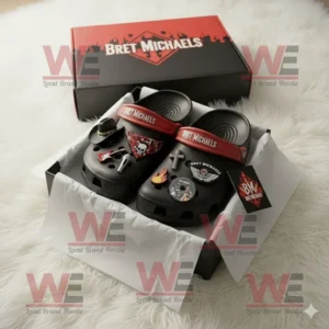 Bret Michaels Crocs Clogs With Charms 5 Bret Michaels inspired Crocs packaged in an open box with multiple charms such as guitar cross wings and fire symbol on a soft white rug!