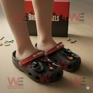 Bret Michaels Crocs Clogs With Charms 6 Bret Michaels Crocs worn by a person highlighting charms inspired by rock music elements in front of the branded packaging box!