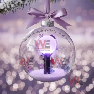 A BTS themed Christmas ornament showing a purple lit concert stage inside a glass ball with a ribbon labeled BTS Stage Winter Edition.