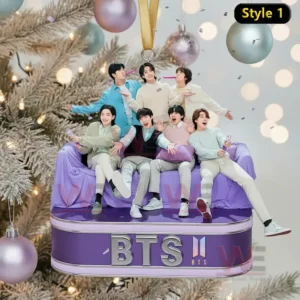 A Christmas ornament depicting seven people sitting on a purple couch in front of a decorated tree with warm lights!