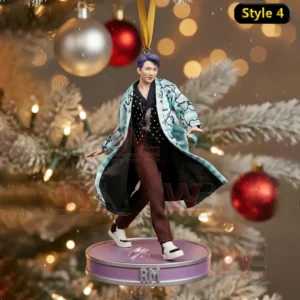 A Christmas ornament showing a person in a blue patterned coat posing on a platform before a decorated tree!