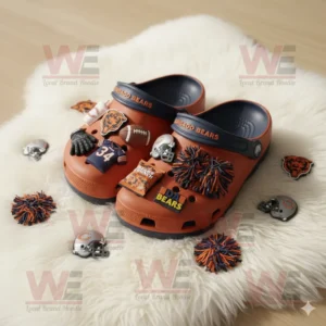 Orange and navy Chicago Bears Crocs with football and cheer themed charms displayed on white fluffy surface.