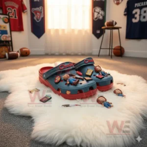 Alt text: Chucky-themed crocs with charms placed on a fluffy rug, surrounded by sports memorabilia like jerseys and footballs.