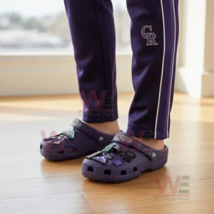 A person wearing purple Colorado Rockies Crocs decorated with baseball charms and matching Rockies pants.