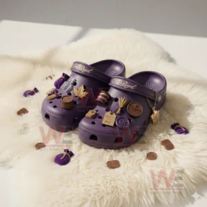 Purple clogs decorated with Crown Royal inspired charms resting on a white furry mat with additional charms placed around them!