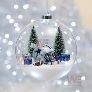 A clear ornament containing a Dallas Cowboys helmet snow trees and gift boxes.