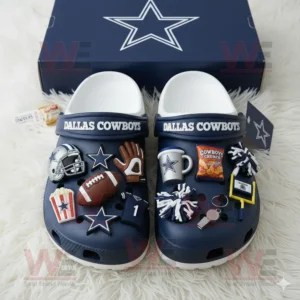 Dallas Cowboys Crocs with football and cheer charms placed near a blue box with the team star emblem.