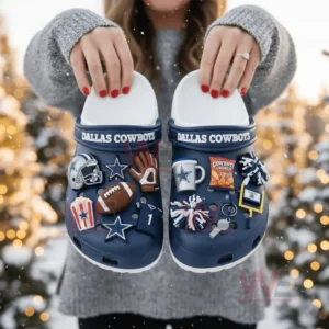 Blue Dallas Cowboys clogs with football charms held by a person in a snowy outdoor scene!