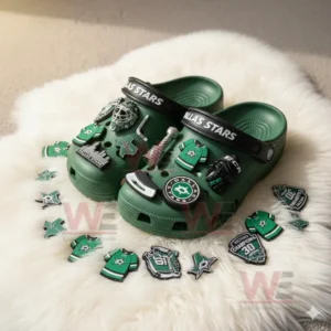 Dallas Stars-themed Crocs with hockey-related charms on a soft surface.