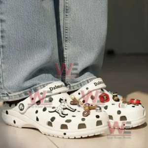 A person wearing Dalmatian themed clogs with denim pants standing indoors!