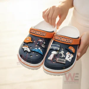 Navy Denver Broncos clogs with football charms displayed on grass in front of a team box!
