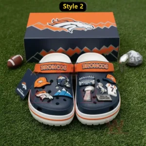 Navy Denver Broncos clogs with football charms displayed on a white furry rug in a sports themed room!