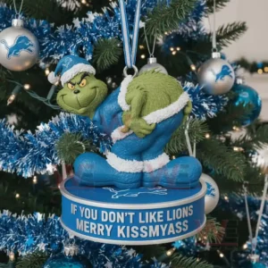 A green costumed character ornament hangs on a decorated Christmas tree with blue tinsel and themed ornaments in the background!