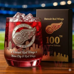 Detroit Red Wings 100th Anniversary Limited Edition Whiskey Glass 3 A Detroit Red Wings anniversary glass with red ice next to a matching box with a hockey arena in the background.