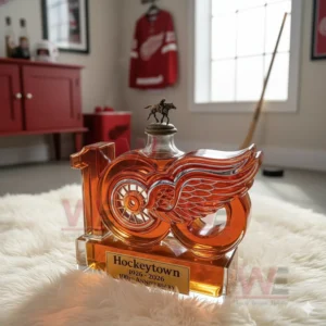 A commemorative bottle featuring the number one hundred and winged wheel logo positioned on a rug with sports decor behind it!
