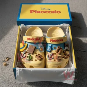 Alt text: Disney Pinocchio-themed crocs with colorful charms inside a box, including a book, bottle, and anchor.