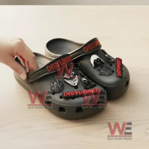 Disturbed Band Crocs Clogs with Charms 6 Close up view of black Disturbed Crocs with a hand adjusting the strap and visible themed charms.