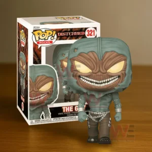 A small collectible figure with a large head glowing eyes and a sinister smile posed in front of its box on a wooden surface.