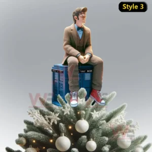 Doctor WHO Christmas Tree Topper 8 A Doctor Who figure sitting casually on the TARDIS atop a frosted Christmas tree decorated with white ornaments and lights.