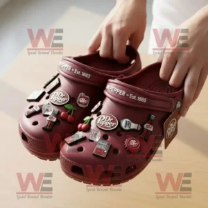 Hands holding maroon Dr Pepper Crocs with soda bottle and cherry charms!