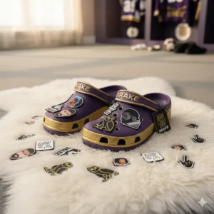 Purple gold Drake Crocs with themed charms on a white rug!