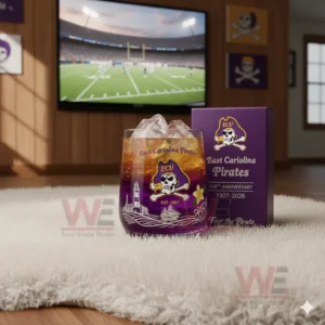 East Carolina Pirates whiskey glass filled with ice, set on a white rug while a football game plays on the TV in the background.
