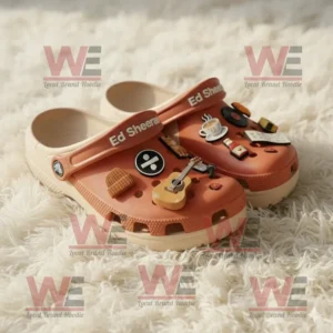 Orange Ed Sheeran Crocs with musical and coffee themed charms on a fluffy white background!