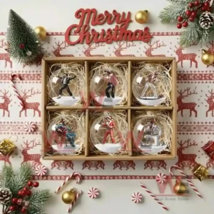 A box of six glass Christmas ornaments containing miniature performers arranged among holiday decorations!