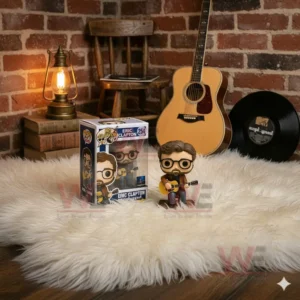 A figure of Eric Clapton playing an acoustic guitar from the Unplugged edition displayed on a soft white rug in front of a brick wall with vintage decor and lighting.
