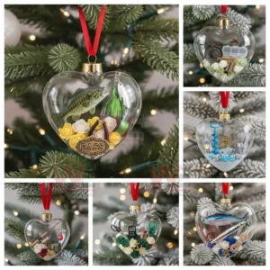 Alt text: Heart-shaped glass ornaments with fishing-themed miniature items such as fish, fishing lures, and tools, hanging on a Christmas tree.