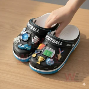 FOOTBALL PREMIUM Crocs Crocband CLOGS WITH CHARMS 4 A pair of football themed clogs being lifted by a hand showing multiple sporty charms on the tops!