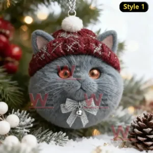 A gray cat ornament with a red knit hat and silver bow hanging on a Christmas tree!