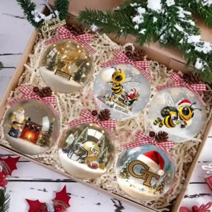 A set of six Georgia Tech Yellow Jackets-themed Christmas ornaments with designs such as a Santa figurine, football helmet, and Christmas trees, all packaged in a festive box.