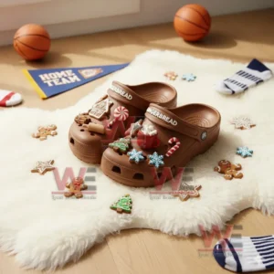 Brown clogs with gingerbread themed charms on a fluffy rug surrounded by assorted holiday cookies! `
